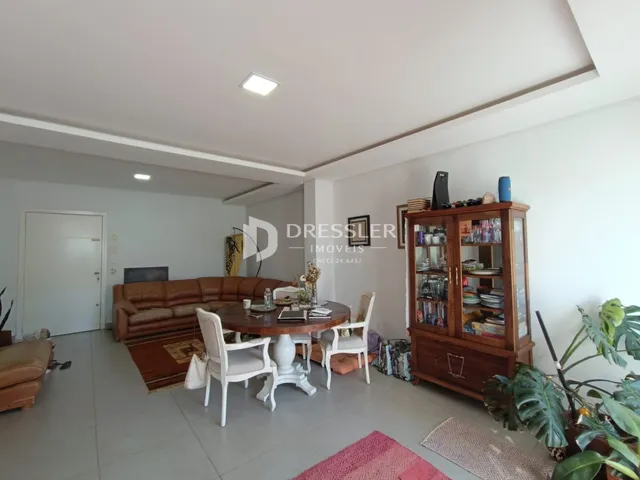 Sala de estar com sofá e mesa de jantar em um apartamento.