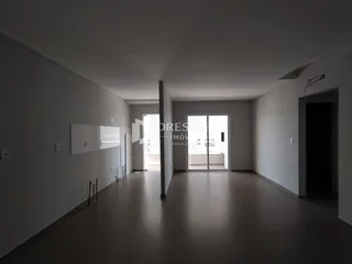 Corredor interno com paredes brancas e piso claro.