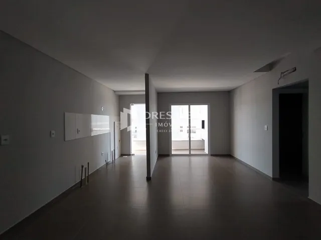 Corredor interno com paredes brancas e piso claro.