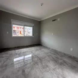 Ambiente interno com paredes claras e piso de concreto.