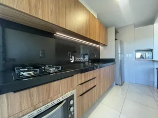 Cozinha moderna com armários de madeira e bancada escura.