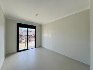 Sala de estar com porta de vidro abrindo para o exterior.