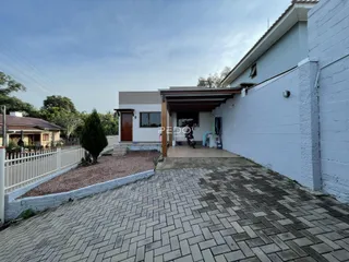 Vista da fachada de uma residência em Lajeado, Brasil, com área pavimentada na frente.