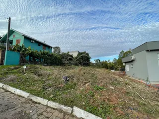 Vista externa de uma residência em Lajeado com área de grama alta no primeiro plano.