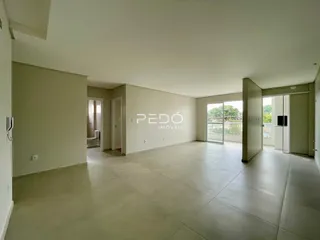 Vista interna de uma sala ampla com piso claro e paredes neutras.