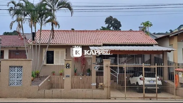 Fachada de uma residência em Lajeado, Brasil, com telhado de telhas vermelhas.