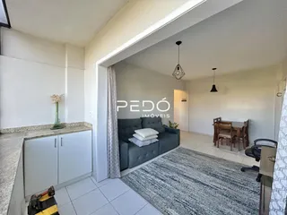 Sala de estar com sofá e tapete em ambiente interno.