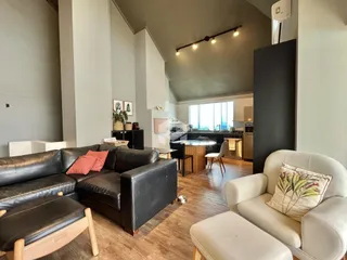 Sala de estar ampla com sofá e área de cozinha integrada.