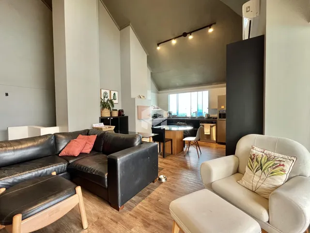 Sala de estar ampla com sofá e área de cozinha integrada.