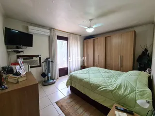 Quarto com cama e armário de madeira em um imóvel no Brasil.
