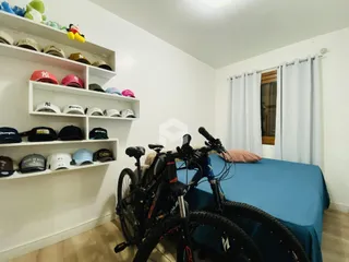 Quarto com estantes brancas e bicicletas em um ambiente claro.
