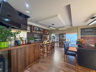 Interior moderno com piso de madeira e área de cozinha integrada.
