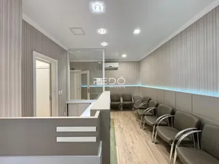 Vista de um corredor interno com paredes texturizadas e piso de madeira.