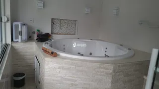 Banho com banheira branca em ambiente de banheiro.
