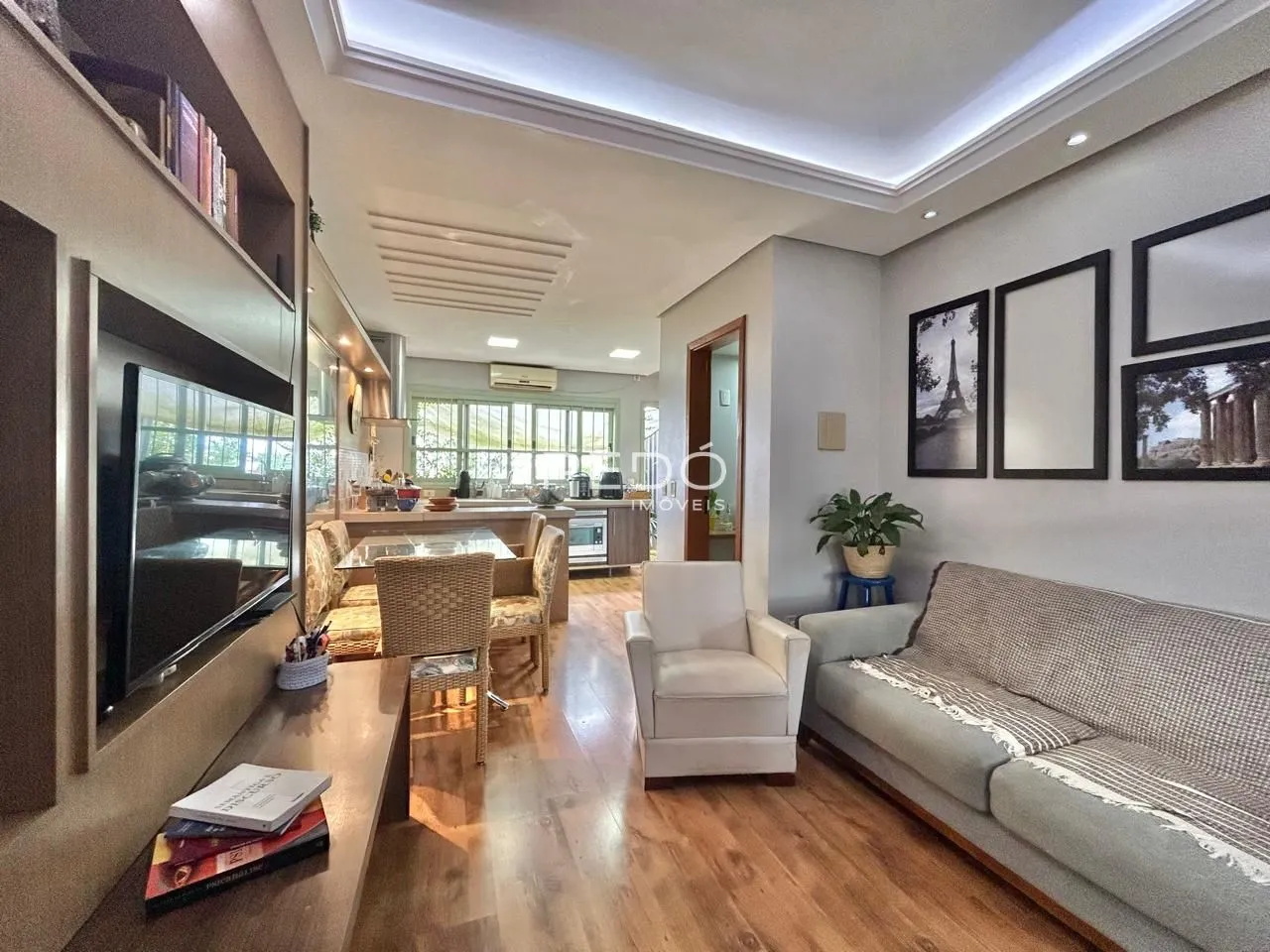 Sala de estar e jantar com piso de madeira clara e decoração moderna.