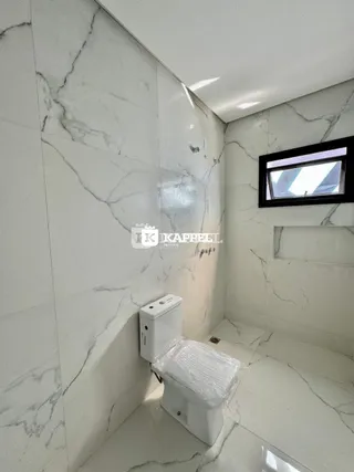 Foto de um banheiro com revestimento em mármore branco.