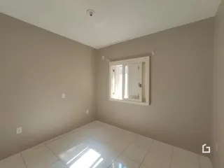 Quarto interno com janela e piso de cerâmica em uma residência.