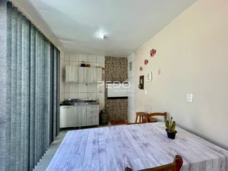Foto de uma área interna com cozinha e mesa de jantar em um imóvel.