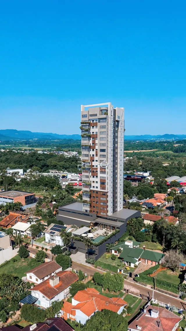 Vista aérea de um prédio residencial em Lajeado, Brasil, cercado por áreas verdes.