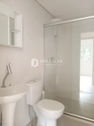 Foto interna de um banheiro com vaso sanitário e box de vidro.