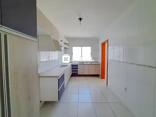 Esta é uma cozinha com armários brancos e piso de cerâmica.
