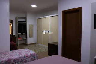 Quarto interno com cama e armário de madeira.