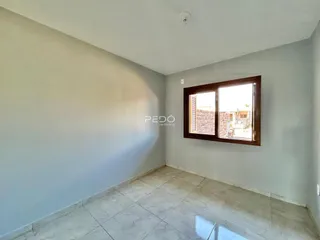 Interior de uma sala com paredes cinzas e piso de cerâmica.