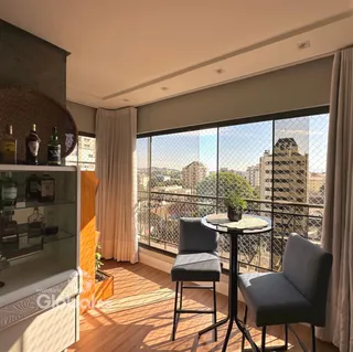 Sala de estar com vista para a cidade através de uma grande janela.