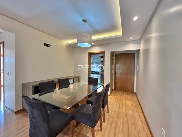 Uma sala de jantar com mesa de vidro e cadeiras em um imóvel no Brasil.