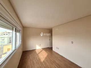 Vista interna de um corredor com piso de madeira clara.
