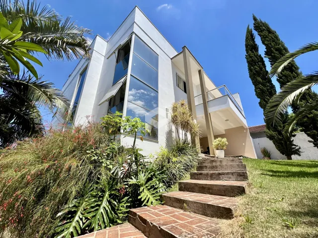 Fachada de uma residência moderna em Lajeado, Brasil, com jardim exuberante na frente.