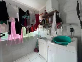 Interior de um ambiente com máquina de lavar e área de serviço.