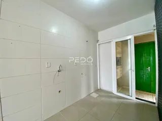 Um corredor com paredes de azulejo branco e piso claro é visível na propriedade.