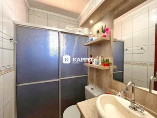 Banheiro com pia e box de vidro em um imóvel.