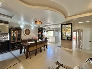 Sala de jantar ampla com mesa de madeira e decoração moderna.