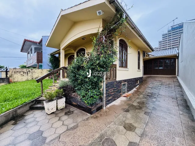 Fachada de uma casa em Lajeado, Brasil, com jardim e calçada de pedras.