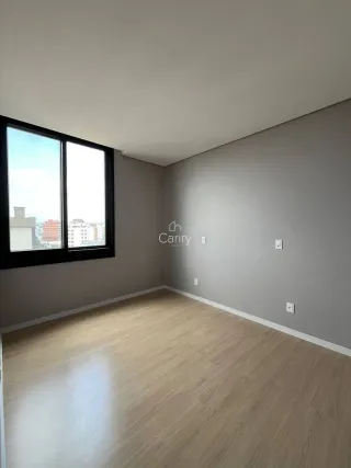 Uma foto de um cômodo interno com piso de madeira e grande janela.