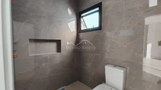 Foto interna de um banheiro com revestimento em mármore cinza e nicho.