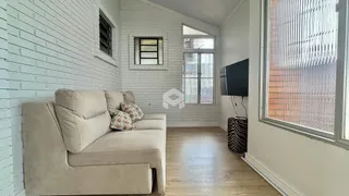 Sala de estar com sofá e piso de madeira em uma residência.