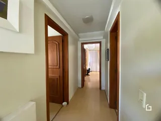 Corredor interno com portas de madeira em uma residência.