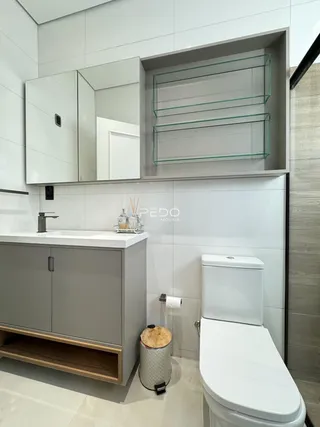 Foto de um banheiro moderno com revestimento branco e louças brancas.