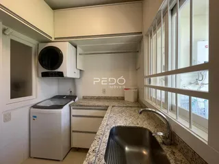 Cozinha com armários brancos e bancada de granito.
