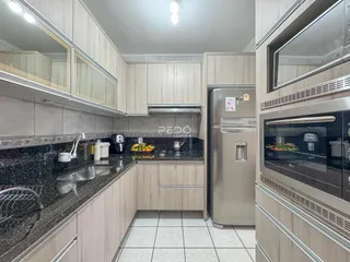 Cozinha moderna com armários e bancadas de granito.