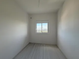 Vista interna de um cômodo com paredes brancas e piso claro.