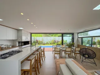 Sala de jantar e cozinha com acesso a um jardim externo.