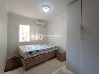 Quarto com cama e janela bem iluminada.