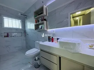 Banheiro moderno com revestimento em mármore cinza nas paredes.
