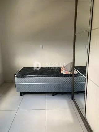 Quarto com cama e piso de cerâmica claro.