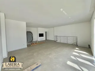 Ambiente interno amplo e vazio com piso de cerâmica clara.