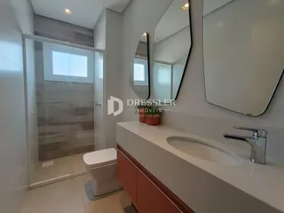 Banheiro moderno com bancada e box de vidro.